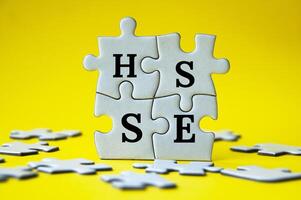 testo breve di hsse su puzzle con sfondo giallo - salute, sicurezza e ambiente. concetto di sicurezza. foto