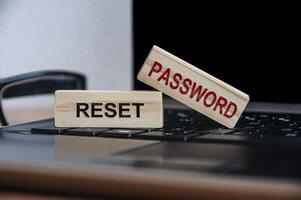 resto il testo della password su blocchi di legno sopra un laptop. sicurezza online e concetto di password foto