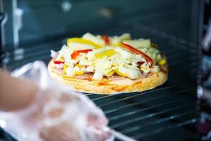 cucinare pizza fatta in casa usando il forno a casa foto