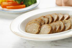 galantine o polpettone è un pollo macinato arrotolato con farina, servito con verdure al vapore e salsa barbecue foto