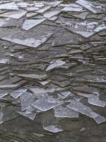 pezzi di ghiaccio frantumati sulla superficie dell'acqua. primo piano strutturato del fondo. foto