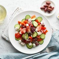 insalata greca horiatiki con formaggio feta, olive, pomodorini, cetriolo e cipolla rossa foto