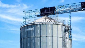 grandi serbatoi industriali per benzina e olio con cielo blu. serbatoi di carburante presso la tank farm. scale di metallo sul lato di un contenitore industriale dell'olio. scala su grande serbatoio carburante foto