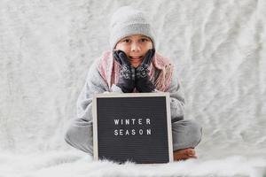 un ragazzo che indossa abiti invernali accoglie felicemente la stagione invernale foto