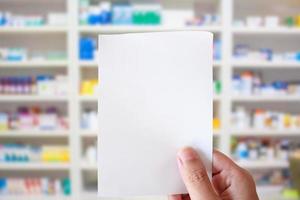 mano del farmacista con carta da prescrizione in bianco in farmacia foto