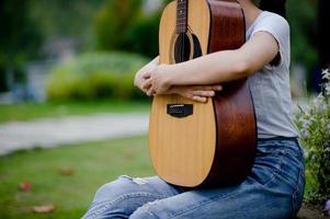 la donna suona la chitarra felicemente. carino, brillante, felice di suonare musica che ama i concetti musicali foto