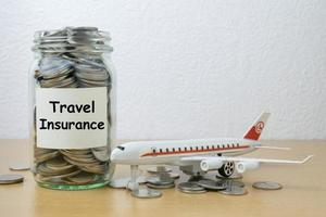 risparmio di denaro per l'assicurazione di viaggio nella bottiglia di vetro foto