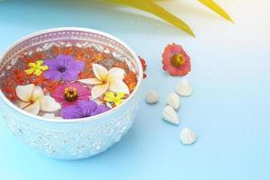 thai songkran festival - ciotola d'argento con fiori colorati e polvere di gesso su blu foto