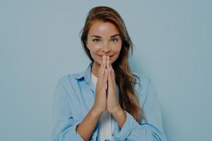 felice calmo grato modello femminile mani pieghevoli per pregare il gesto di namaste foto