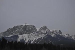 montagne rocciose innevate con cielo grigio nebbioso foto