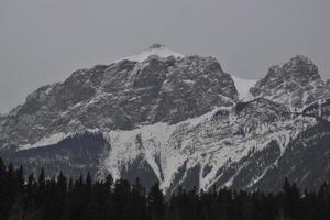 montagne rocciose innevate con cielo grigio nebbioso foto