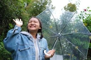 sorriso ragazza divertendosi sotto la pioggia. foto