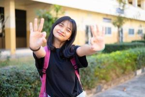 studentessa ragazza tiene libro rosa e zaino a scuola, torna a scuola. foto