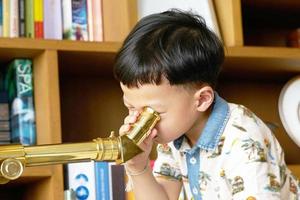 bambino o ragazzo usa il telescopio da solo foto