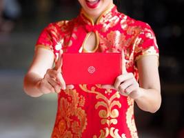 le donne asiatiche in costumi nazionali cinesi tengono il biglietto di auguri per l'evento del capodanno cinese foto