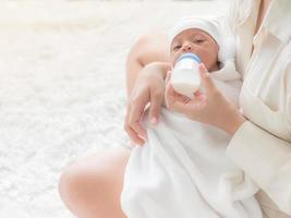 una bella donna asiatica, che porta il suo neonato con amore e affetto foto