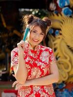 le donne asiatiche in costumi nazionali cinesi tengono un ventaglio di legno per l'evento del capodanno cinese foto