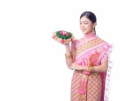 attraente donna tailandese vestita con abiti tradizionali tailandesi tiene un cesto di fiori foto