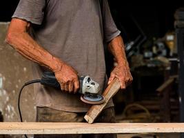 i tecnici professionisti in fabbrica utilizzano utensili elettrici per lucidare il legno foto