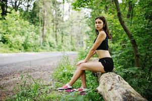 ragazza sportiva in abbigliamento sportivo che riposa in un parco verde dopo l'allenamento in natura. uno stile di vita sano. foto