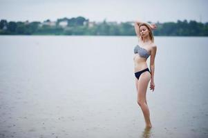 ritratto di una bellissima modella in bikini in piedi e in posa nell'acqua. foto