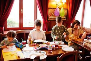 preparazione al concetto di pasqua. bambini con la madre che fa a mano coniglietto e uova. foto