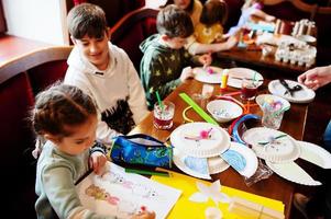 preparazione al concetto di pasqua. bambini che fanno a mano coniglietto e uova. foto