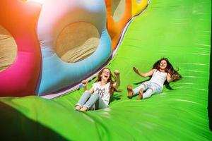 bellissime ragazze che si divertono su uno scivolo in una giornata di sole. foto