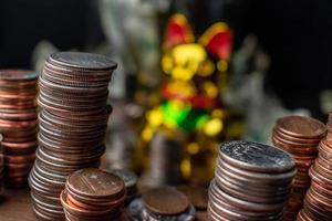 pile di monete che incorniciano la vista di buona fortuna gatto della fortuna d'oro e denaro cartaceo in background foto