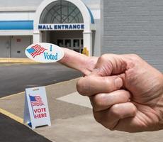 mano con adesivo all'ingresso di un seggio elettorale per le elezioni nel vecchio centro commerciale foto
