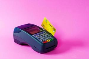 scanner per carte di credito e carte di credito su sfondo rosa foto