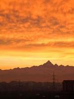 tramonto rosso con nuvole e skyline di montagne foto