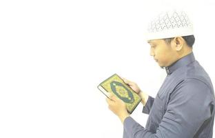 uomo che tiene e legge il Corano. sfondo islamico foto