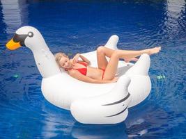 la giovane bella donna caucasica si sta rilassando in piscina sul gonfiabile. foto