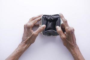 le donne anziane aprono a mano un portafoglio vuoto con lo spazio della copia. foto