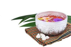 concetto di festival tailandese di Songkran - ciotola d'acqua con fiori colorati foto