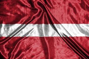 bandiera di stoffa lettonia bandiera di raso sventolando la trama del tessuto della bandiera foto