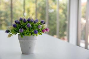 composizione semplice con bouquet di fiori artificiali in vaso di vetro decorato. elementi decorativi rustici fatti a mano. stile romantico. design vintage foto