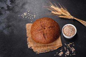 pane integrale appena sfornato con spighe e chicchi di grano foto