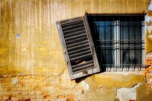 persiana in legno che pende da un edificio abbandonato a monza foto