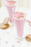 frullato di fragole rosa con biscotti marroni su rusti marrone chiaro foto
