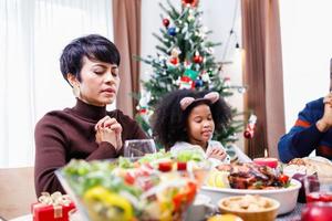 famiglie insieme per pregare prima dei pasti a casa. foto