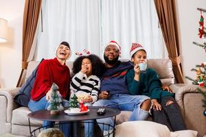 famiglia afroamericana in tema natalizio. la famiglia felice si diverte a sedersi insieme sul divano di casa. foto