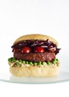 hamburger vegetariano di barbabietole e fagioli con pomodori e piselli. foto