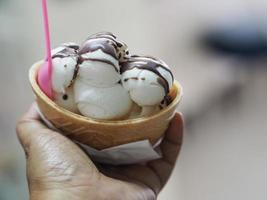 gelato al latte di cocco in una tazza di cialda croccante in mano di donna foto