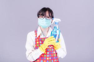 le donne asiatiche devono usare maschere per prevenire l'inquinamento da polvere e prevenire l'infezione da virus che si diffondono nell'aria pulendo con spray alcolico foto