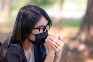 le donne d'affari asiatiche devono usare una maschera per prevenire l'inquinamento da polvere e prevenire l'infezione da virus, durante lo scoppio del virus corona che deve lavorare a casa foto