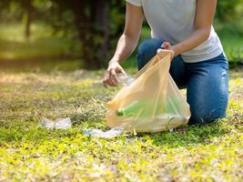 donne volontarie raccolgono bottiglie d'acqua di plastica nell'area del parco foto