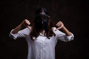 le donne asiatiche stressate devono usare una maschera antigas per prevenire l'inquinamento da polvere e prevenire l'infezione da virus che si diffondono nell'aria foto