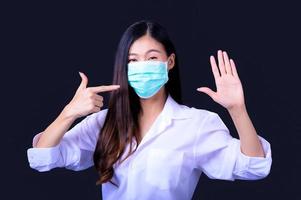 le donne asiatiche devono usare una maschera per coprire il viso per prevenire l'inquinamento da polvere foto